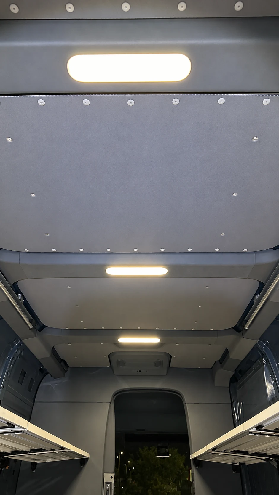 Cargo van interior with fitted thermal lining and shelving.